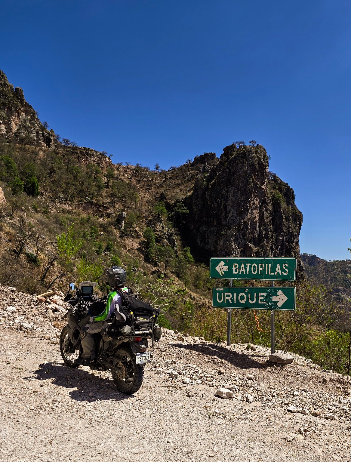 Motocicleta en un camino de terracería junto a los señalamientos hacia Batopilas y Urique