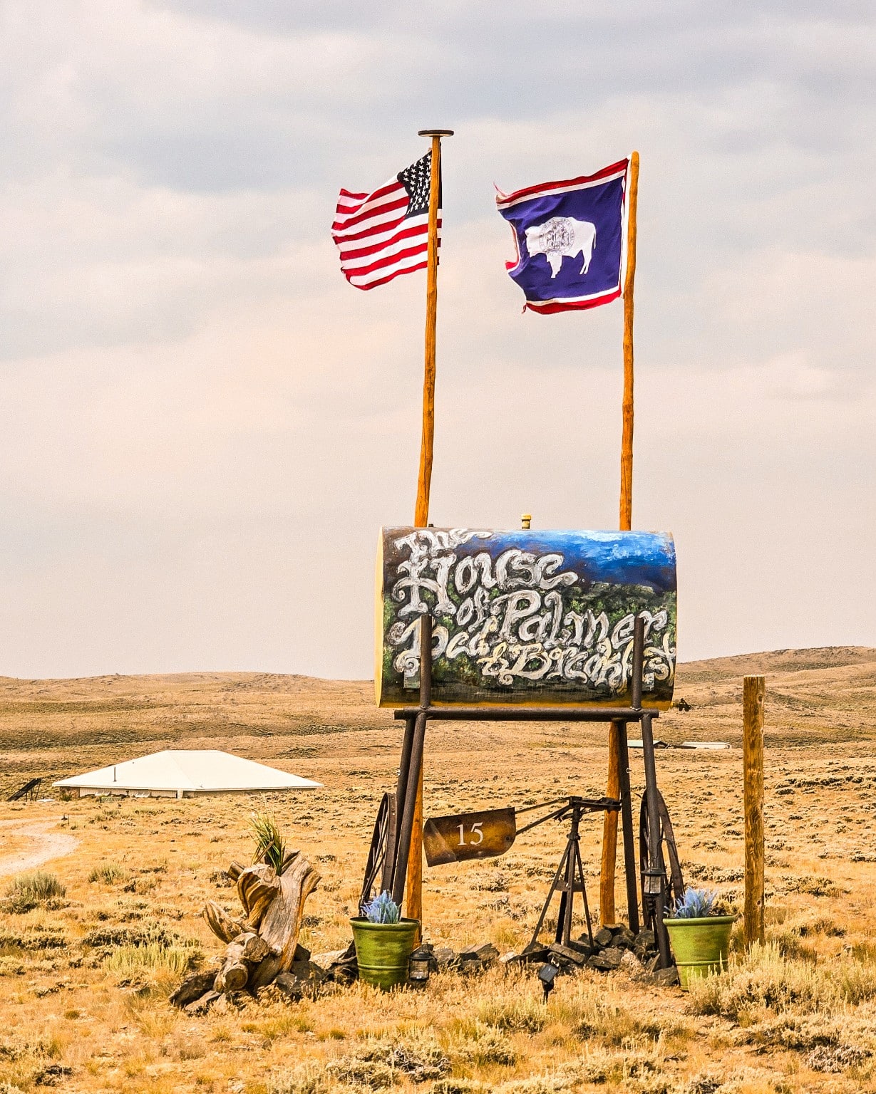 Banderas de Estados Unidos y Wyoming junto a un letrero de rancho