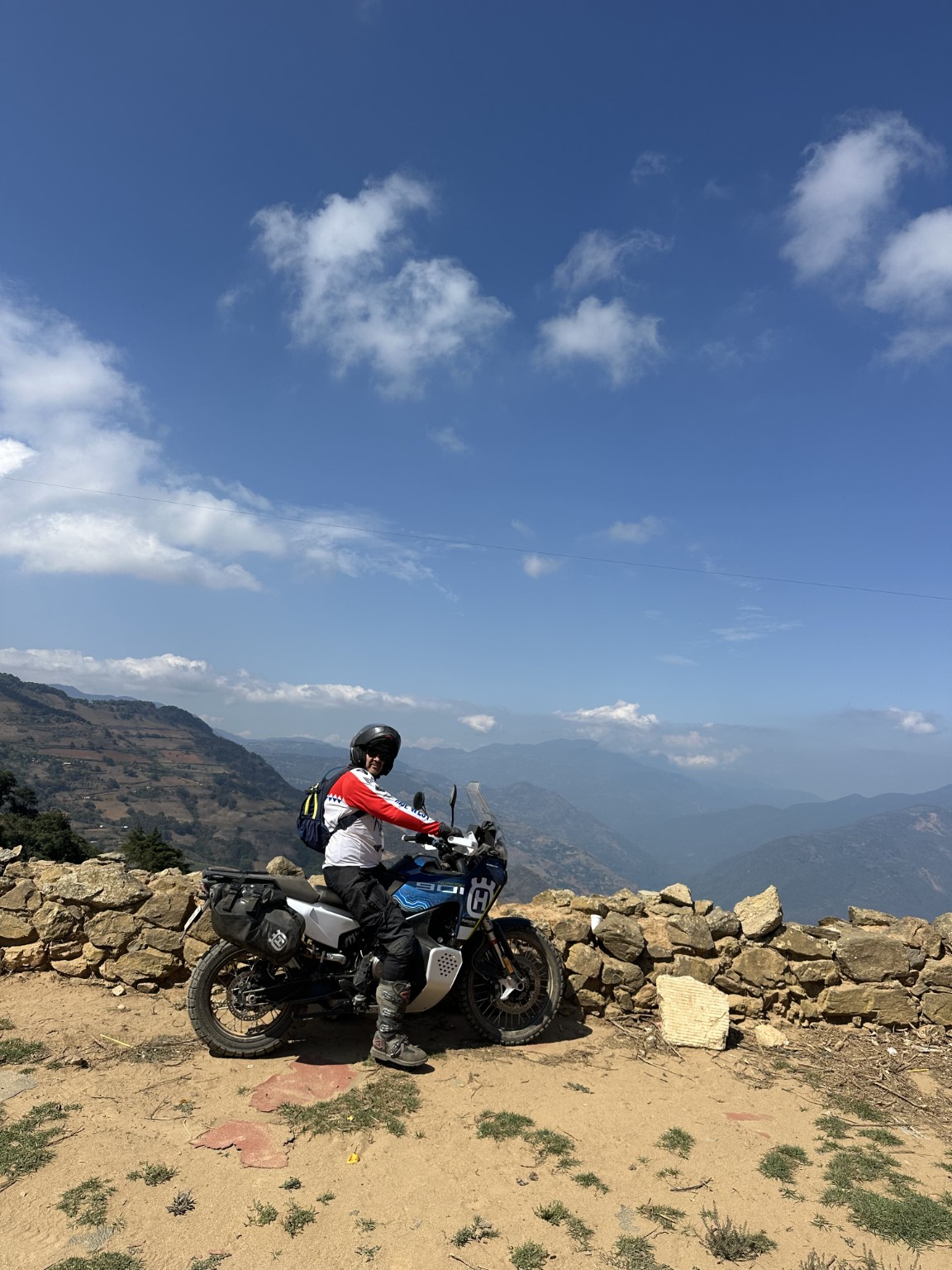 Motociclista en un mirador frente a las montañas